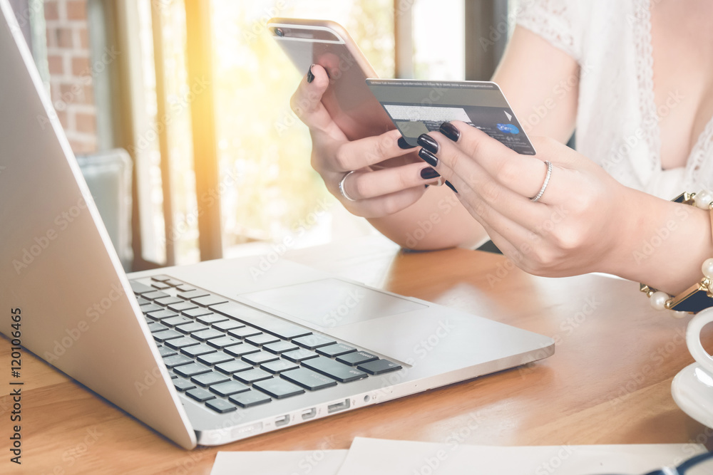 Online payment,Woman's hands holding a credit card and using sma Online payment,Woman's hands holding a credit card and using sma