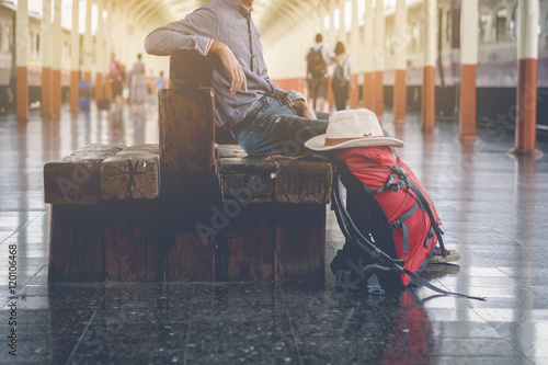 Backpack and hat at the train station with a traveler. Travel co