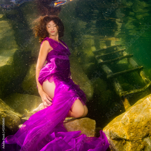 The girl in a dress under water