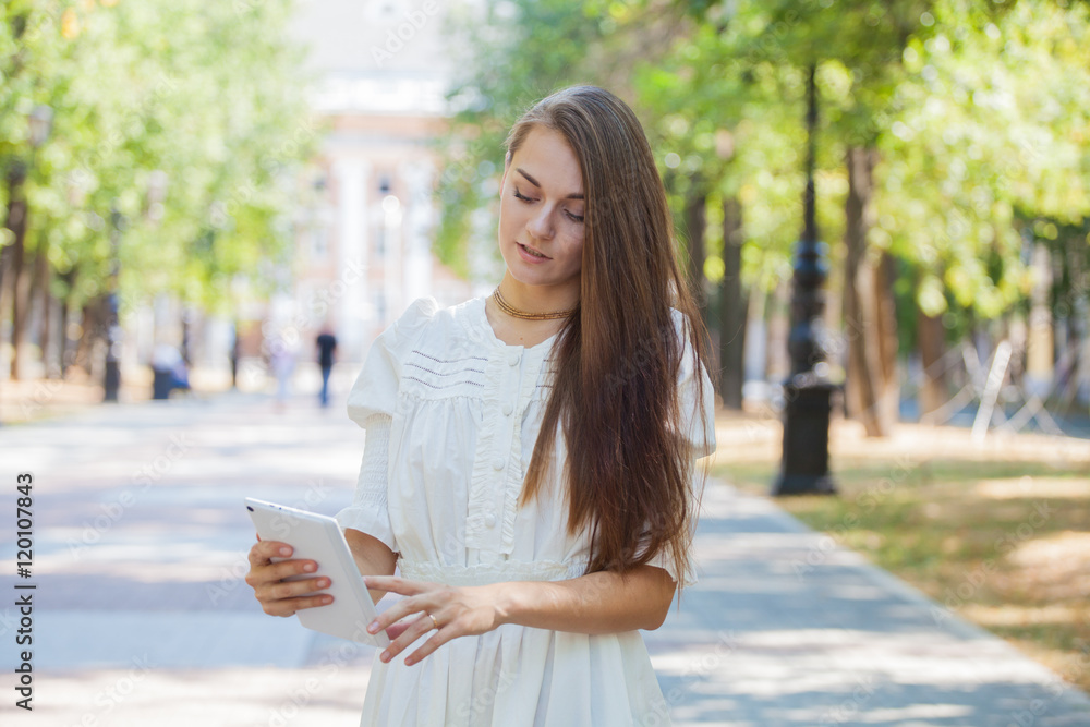 Obraz premium beautiful girl on the background of the city using the navigation on the tablet