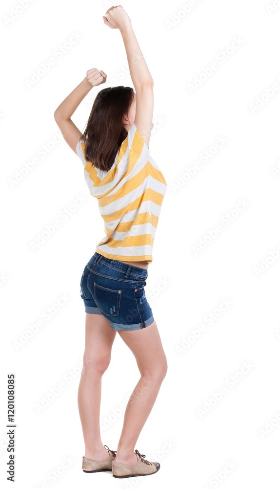 Back view of joyful woman celebrating victory hands up. Rear view people collection. backside view of person. Isolated over white background. slender brunette in a jeans shows the symbol of success Back view of joyful woman celebrating victory hands up. Rear view people collection. backside view of person. Isolated over white background. slender brunette in a jeans shows the symbol of success