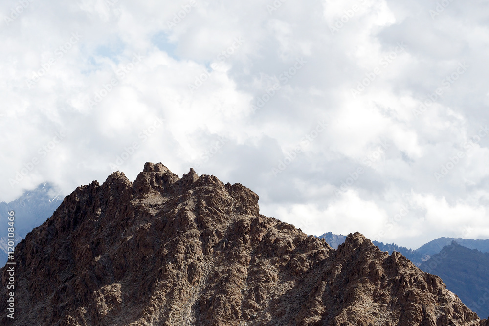 Top of rock mountain in blue cloud sky - with copyspace in Leh Ladakh India. Top of rock mountain in blue cloud sky - with copyspace in Leh Ladakh India.
