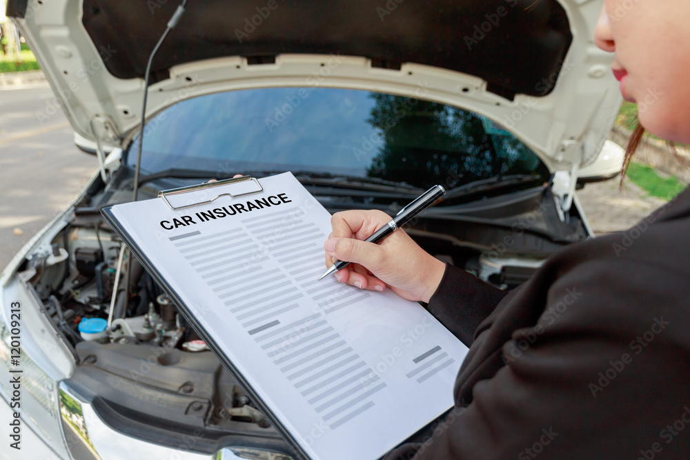 Insurance agent writing on clipboard and examining car Insurance agent writing on clipboard and examining car