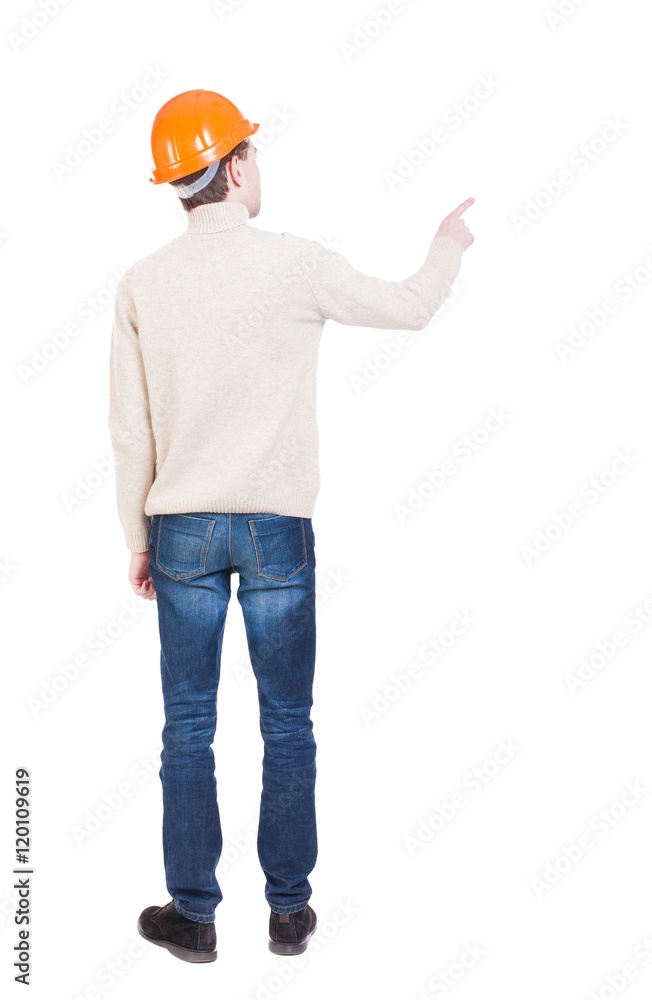 Back view of pointing young men in helmet. Young guy gesture. Rear view people collection. backside view of person. Isolated over white background. Engineer points a finger somewhere Back view of pointing young men in helmet. Young guy gesture. Rear view people collection. backside view of person. Isolated over white background. Engineer points a finger somewhere