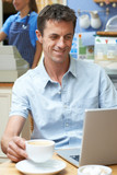 Man In Coffee Shop Using Laptop Computer