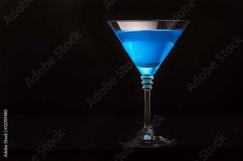 Blue curacao cocktail in martini glasses on black background