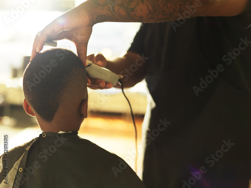 Fotografie little boy getting hair cut by barber