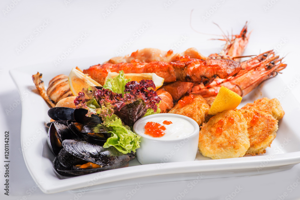 set of grilled seafood grilled on a white plate. Serving for the restaurant menu set of grilled seafood grilled on a white plate. Serving for the restaurant menu