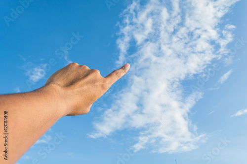 Asian man's index finger points to the bright blue sky with whit