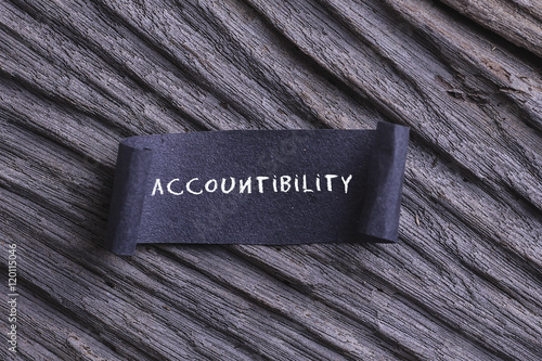 accountability word written on Black papper with wooden background photo