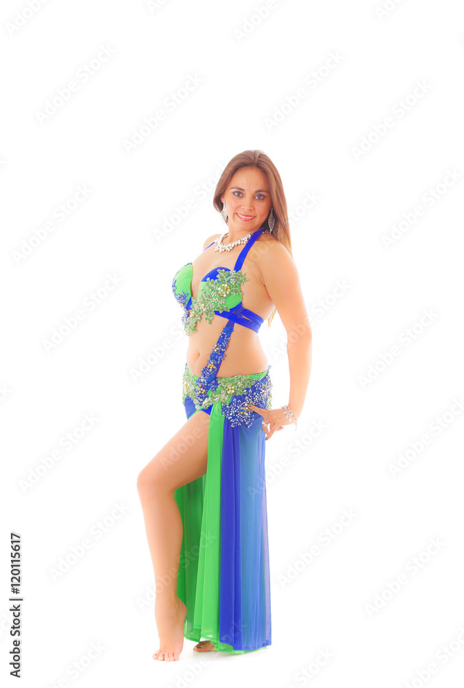 Bellydancer wearing blue colored top with skirt, holding hands above head posing, white studio background
