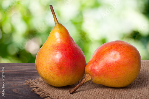two pears on a dark wooden table with blurred background