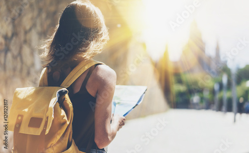 Hipster young girl with bright backpack using and looking at map. Said view tourist traveler enjoying on background panoramic city. Person visiting the sights Barcelona in holiday. Mockup for message photo