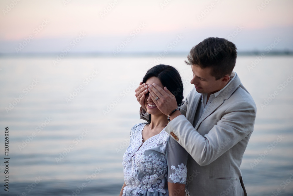 Young couple in love outdoor. Young bride and groom posing at sunset on the beach. young couple on the beach. young couple relaxing at sunset. young couple relaxing on the beach