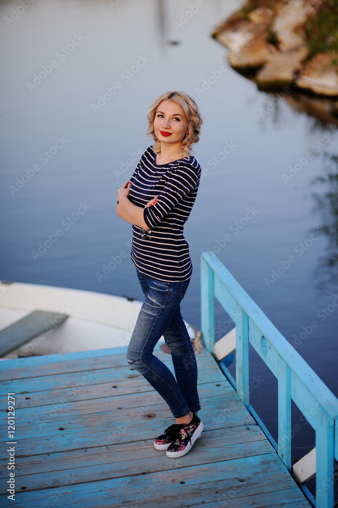 Obraz premium blonde in a striped sweater on a background of water