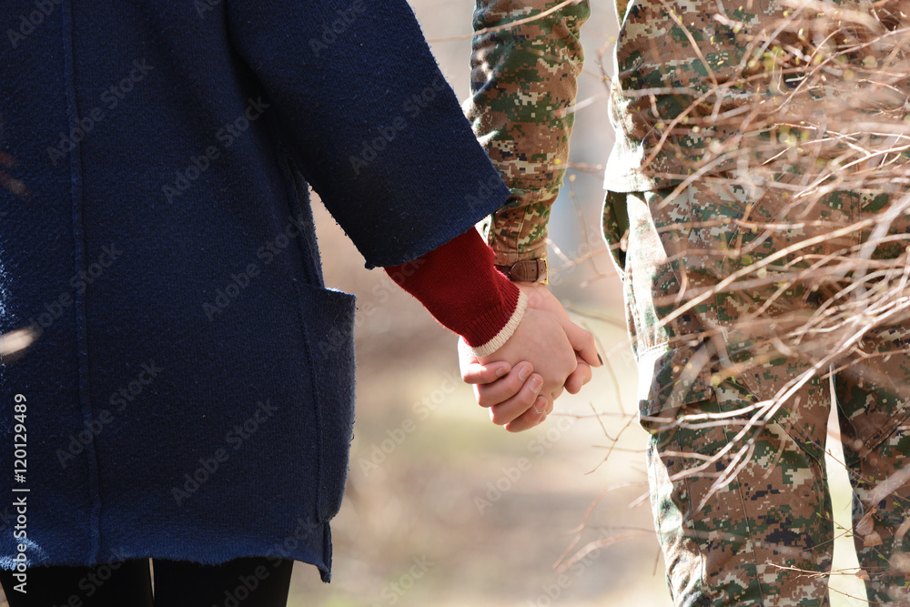 Happy couple holding hands, solder and girl.