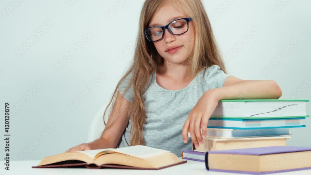 Portrait cute student girl with long blond hair 7-8 years in glasses reading book Portrait cute student girl with long blond hair 7-8 years in glasses reading book