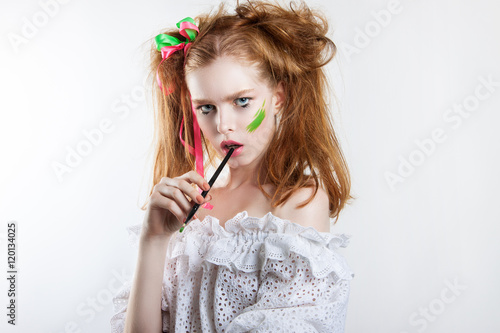 beauty portrait of a young red-haired girl with creative hairstyle and makeup