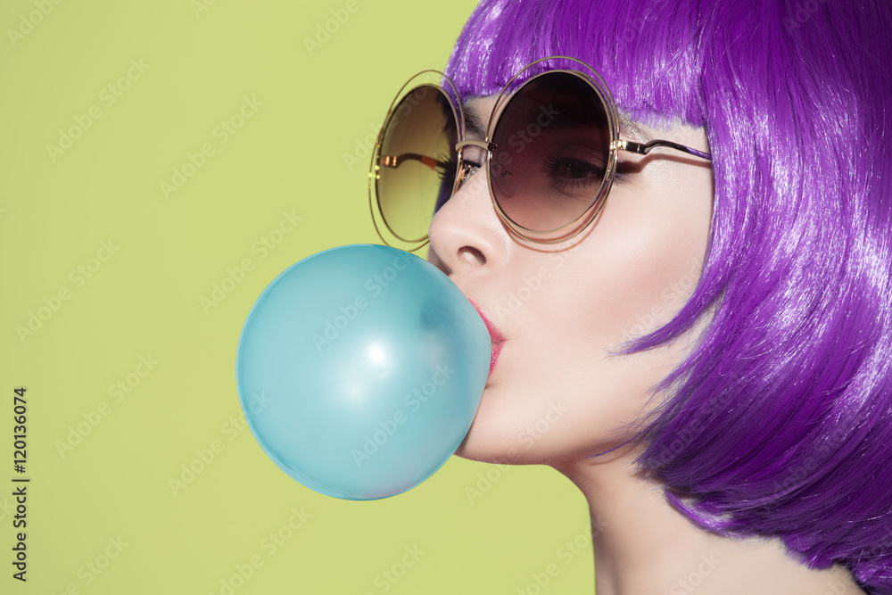Foto Stock Pop art woman portrait wearing purple wig. Blow a blue bubble ch  | Adobe Stock