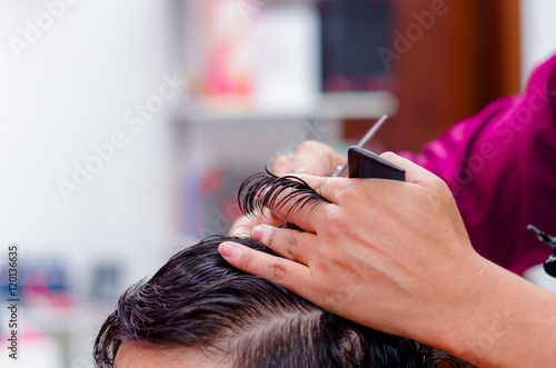 Close up of hair cutting, comb and scissors are used in this process