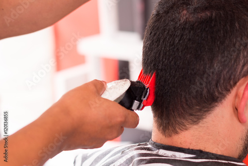 Close up of man hair cut with a machine, red and black tool © Fotos 593
