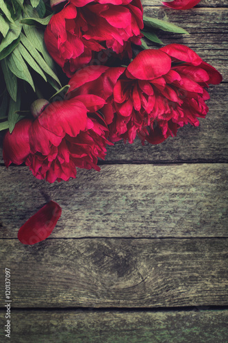 Pink peonies flowers on rustic wooden background. Selective focus  place for text  top view