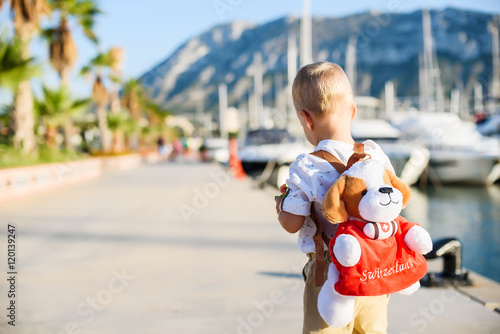 Cute blond boy with toy backpack