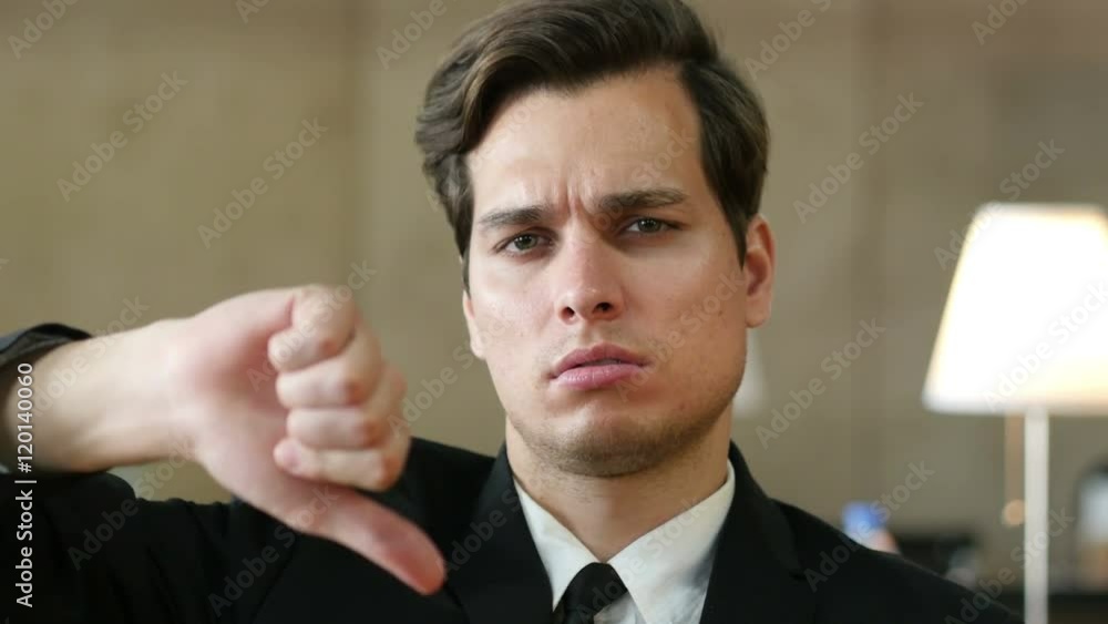 Thumbs Down by Frustrated, Angry Businessman in Office Thumbs Down by Frustrated, Angry Businessman in Office