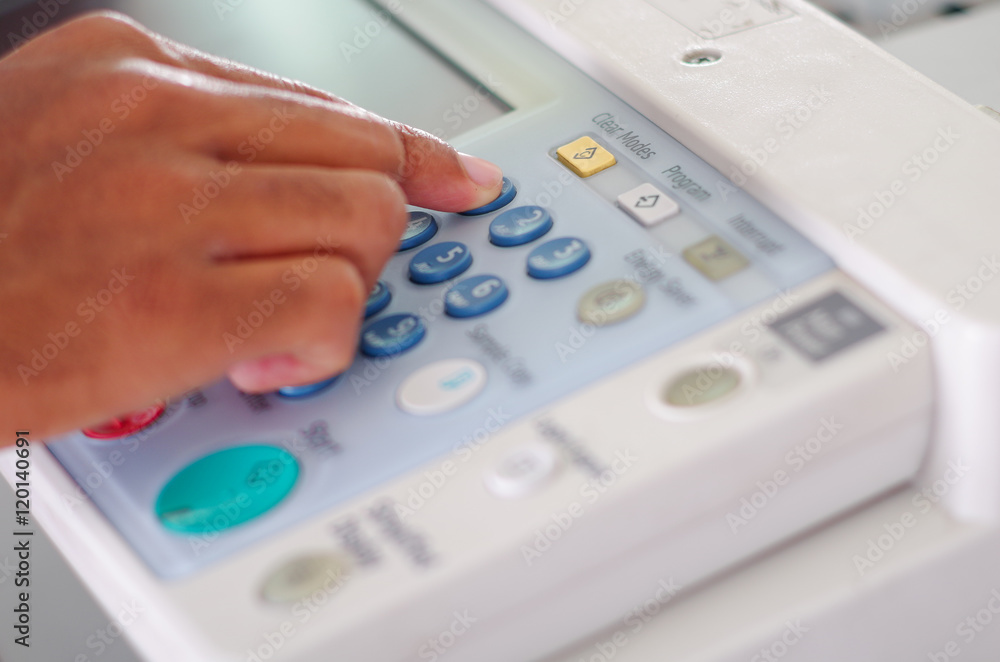 Closeup fingers pressing display buttons on photocopier Closeup fingers pressing display buttons on photocopier