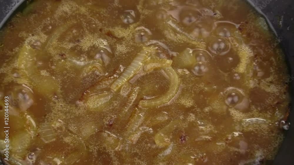 Zoom back from close up of caramelized onions frying in a pan.
Zoom back from close up of caramelized onions frying in a pan.