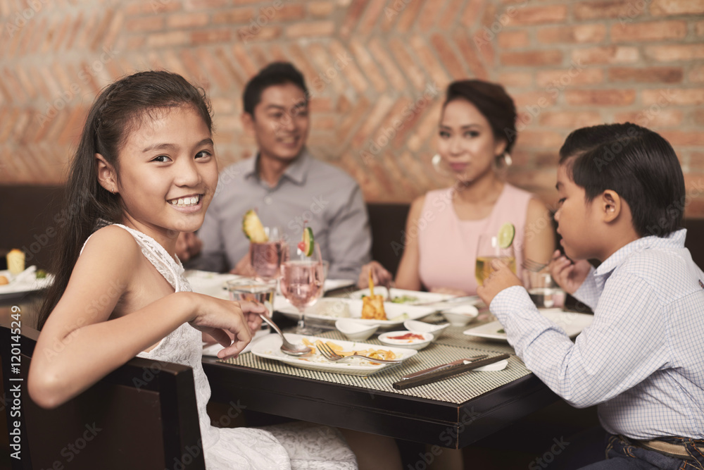 Lovely pretty girl sitting at dinner table and looking at camera Lovely pretty girl sitting at dinner table and looking at camera