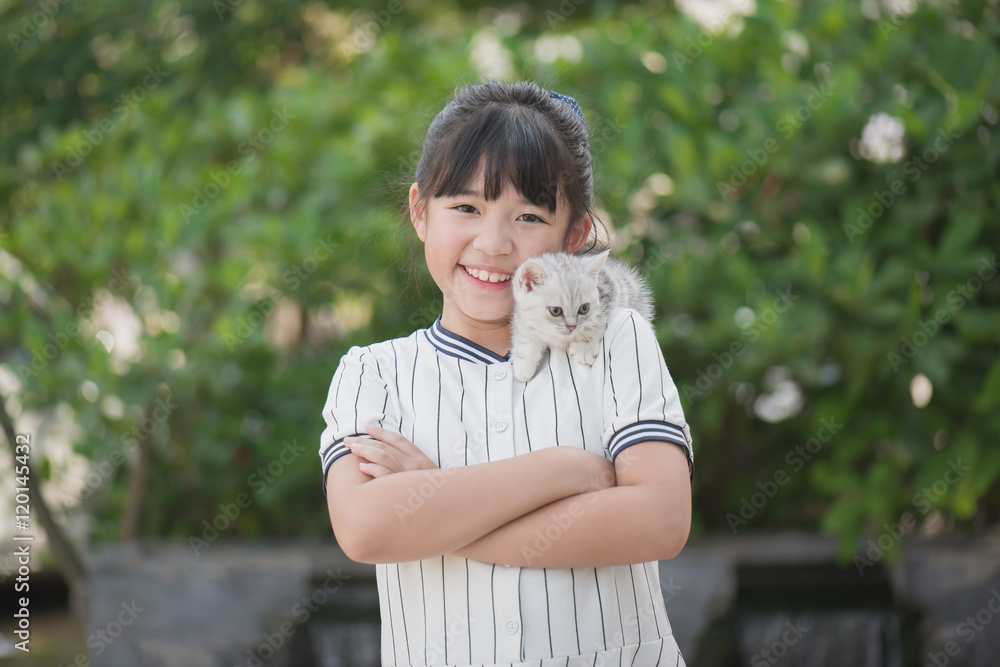 Beautiful Asian girl holding Lovely kitten with sunshine in the park Beautiful Asian girl holding Lovely kitten with sunshine in the park