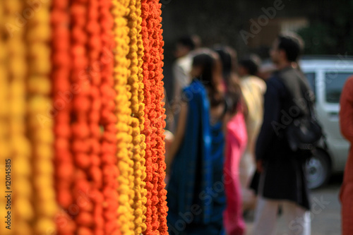 Marigold flowers garland background with people in the background 

