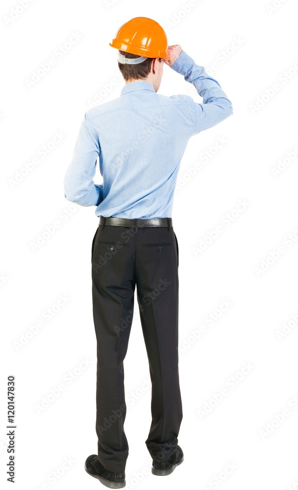Backview of an engineer in construction helmet stands. Standing young guy. Rear view people collection. backside view of person. Isolated over white background. The man in trousers and shirt Backview of an engineer in construction helmet stands. Standing young guy. Rear view people collection. backside view of person. Isolated over white background. The man in trousers and shirt