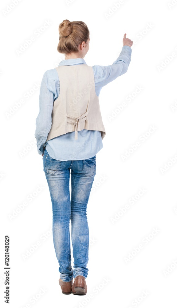 back view of woman. Young woman in vest presses down on something. Isolated over white background. Rear view people collection. backside view of person. she holds his hand open, palm forward