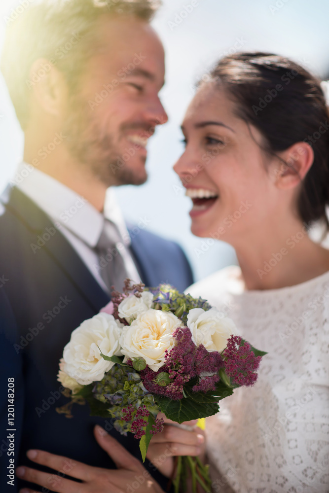 Portrait of smiling newlyweds, focus on the bride's bouquet Portrait of smiling newlyweds, focus on the bride's bouquet