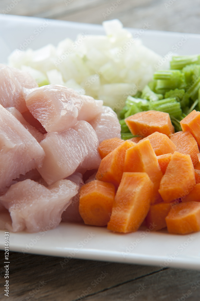 Heap of small piece raw chicken with vegetables Heap of small piece raw chicken with vegetables