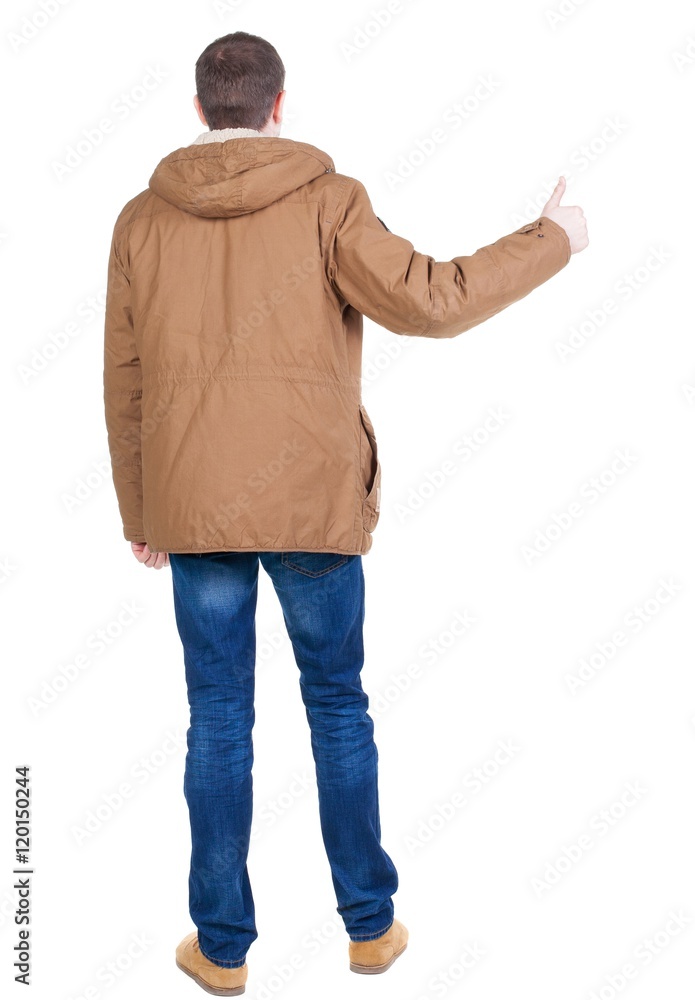 Back view of handsome man in winter jacket shows thumbs up. Standing young guy in parka. Rear view people collection. backside view of person. Isolated over white background. Back view of handsome man in winter jacket shows thumbs up. Standing young guy in parka. Rear view people collection. backside view of person. Isolated over white background.
