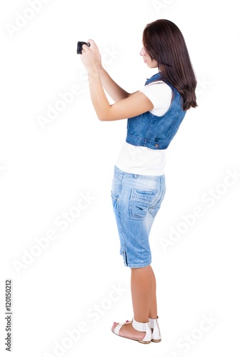 Back view of woman photographing. girl photographer in shorts. Rear view people collection. backside view of person. Isolated over white background.