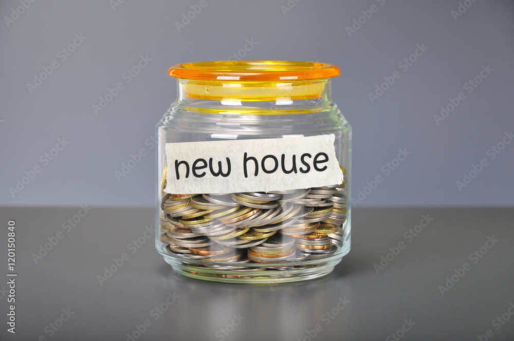 Saving concept of coins in the glass jar for new house purpose Saving concept of coins in the glass jar for new house purpose
