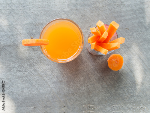 Top view of carrot stick and juice on wooden background