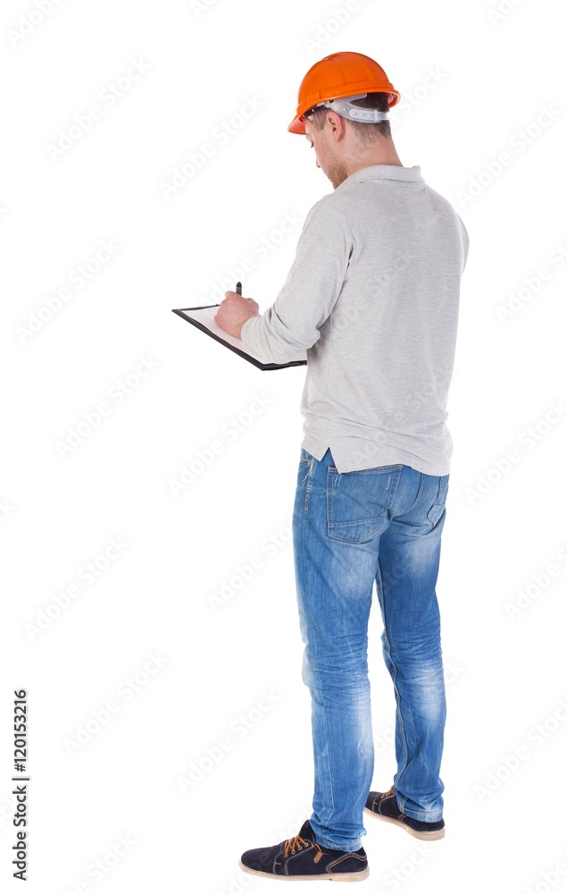 young engineer in a protective helmet with notepad in the hands of. girl watching. Rear view people collection. backside view of person. Isolated over white background. young engineer in a protective helmet with notepad in the hands of. girl watching. Rear view people collection. backside view of person. Isolated over white background.