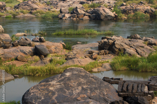 Hampi village Tungabhadra river meadow. Landscape with water, palm, rock, stones. India, Karnataka photo