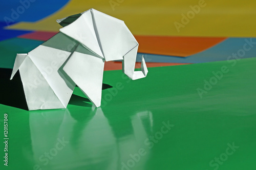 Origami elephant out of paper isolated on a colored background © romanklevets