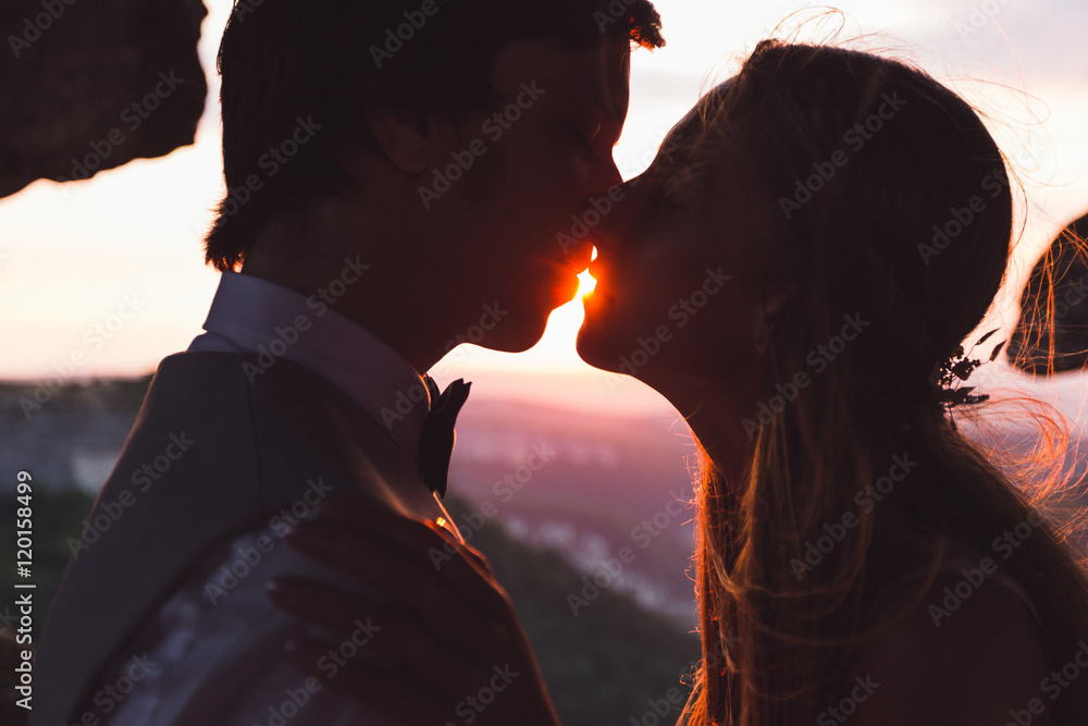 Intimate portrait of the bride and groom in front of the sun Intimate portrait of the bride and groom in front of the sun