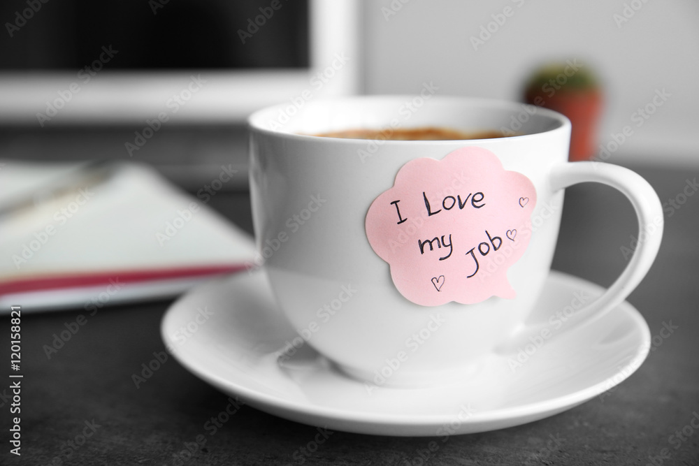 I love my job concept. Cup with hot coffee on grey table I love my job concept. Cup with hot coffee on grey table