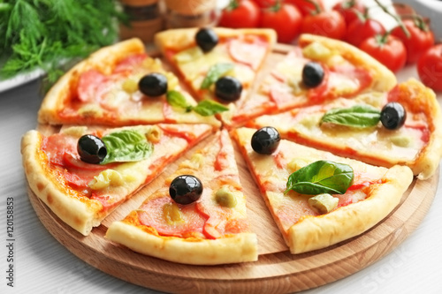 Delicious pizza on wooden cutting board