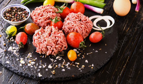 raw minced meat  vegetables with salt and spices  selective focus