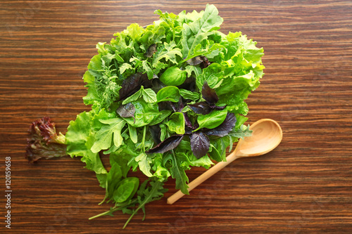 Fresh salad mix in a bowl on  wooden background