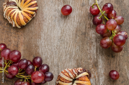 Chocolate croissants and fresh grape on old wooden table. Top vi